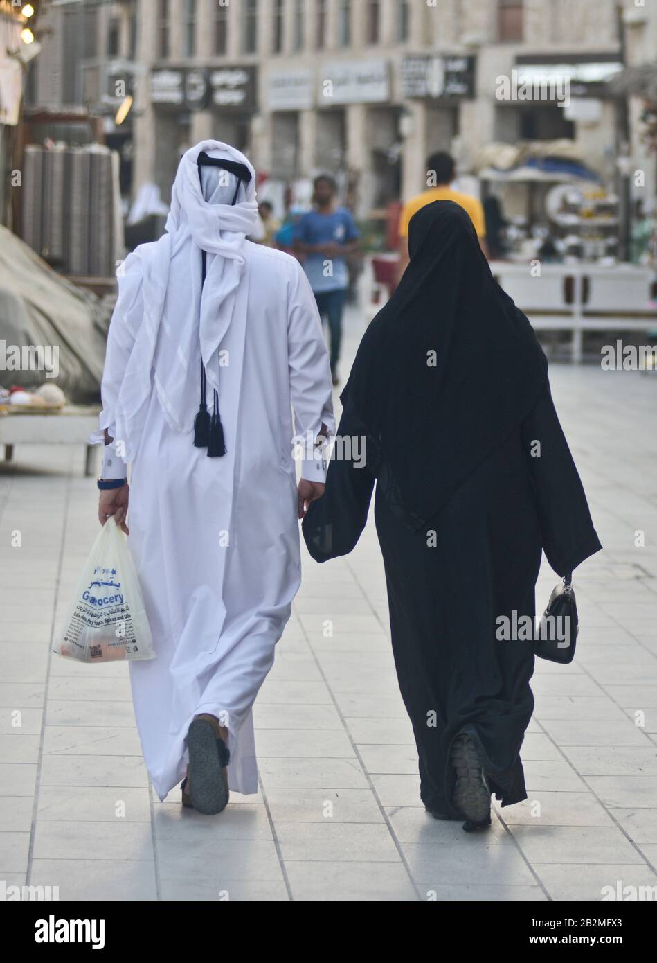 Muslimisches Paar, das in Souq Waqif, Doha, Katar spazieren geht Stockfoto