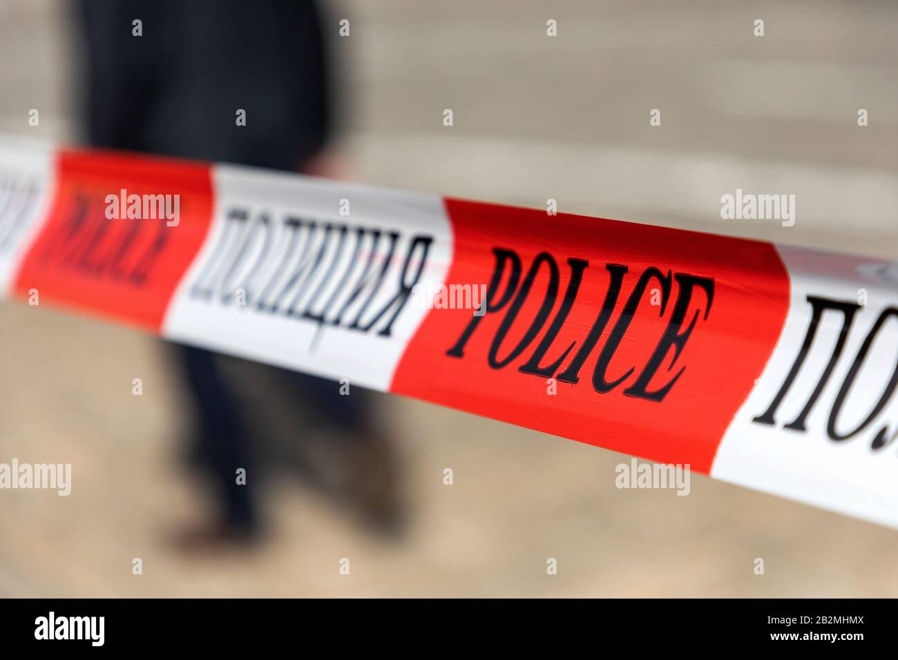 Rot-weißes Polizeiband mit Text: Polizeistreifen überquert außerhalb des öffentlichen Zufahrtsbereichs keine Kurve. Stockfoto
