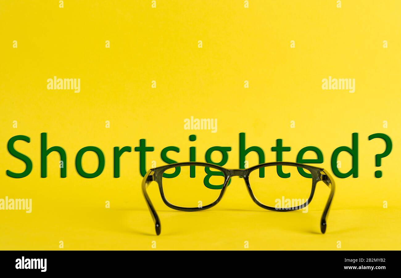 Ein Cocncept über kurzsichtige, mit Brille und verschwommenem Text dargestellte Stockfoto