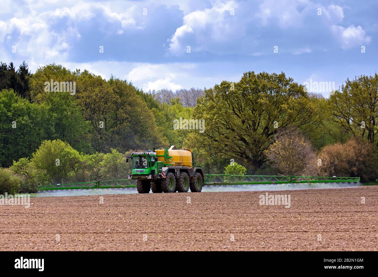 Bauer sprüht im Frühjahr Pestizide/Insektizide/Unkrautmörder/Herbizide über Feld/Ackerland Stockfoto
