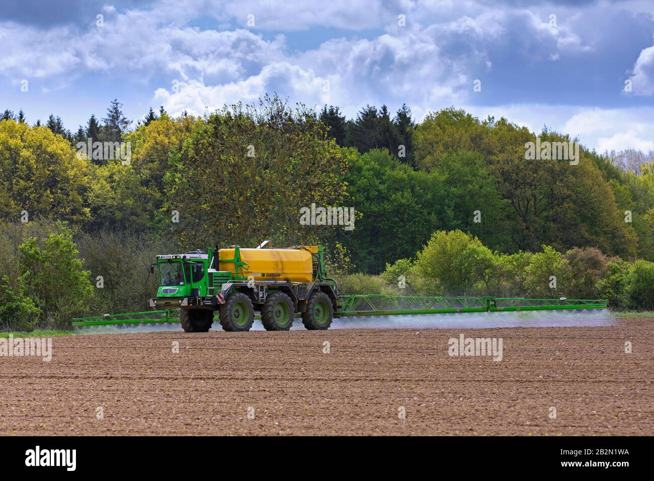 Bauer sprüht im Frühjahr Pestizide/Insektizide/Unkrautmörder/Herbizide über Feld/Ackerland Stockfoto