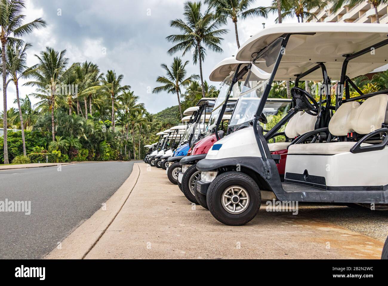 Elektrogolf - in Hamilton Island hintereinander geparkte Personenkraftwagen. Stockfoto