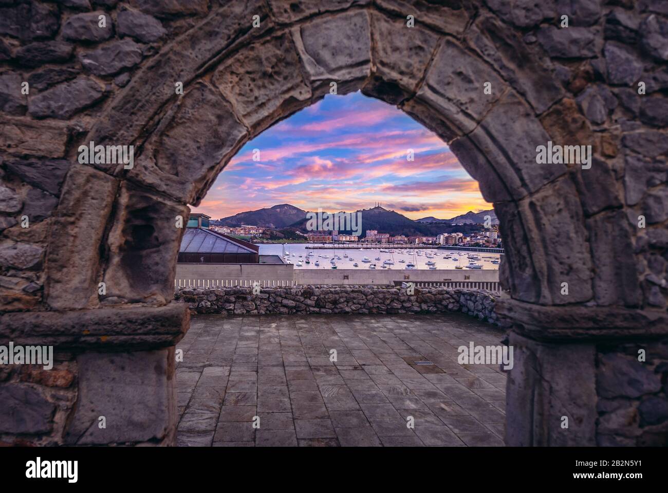 Blick auf den Hafen durch die Ruinen der Einsiedelei San Pedro in der Stadt Castro Urdiales in der Region Kantabrien in Spanien Stockfoto