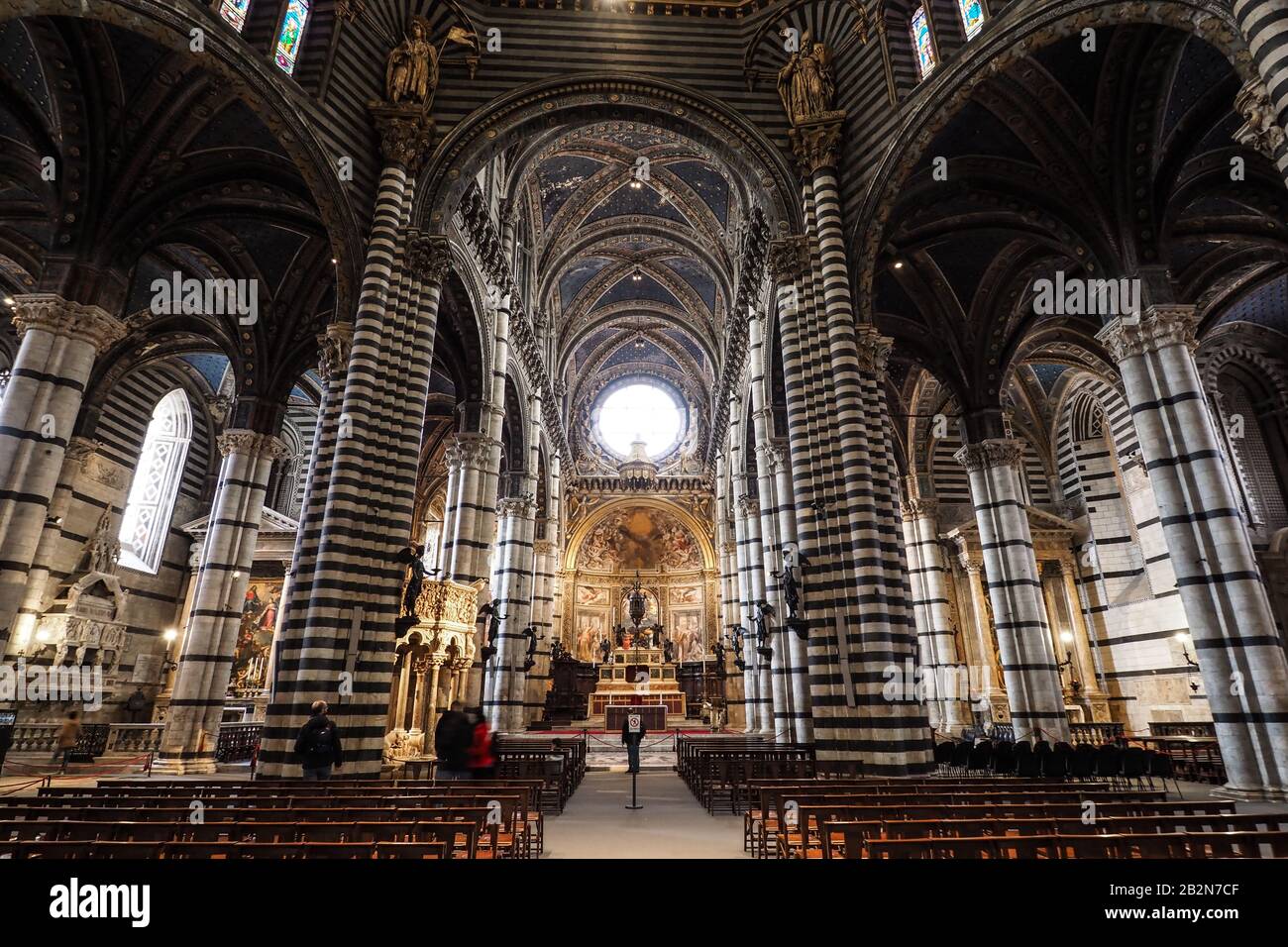 Hauptgang und -Altar aus dem Inneren des Doms von Siena (Dom) mit tagsüber wenigen Besuchern Stockfoto