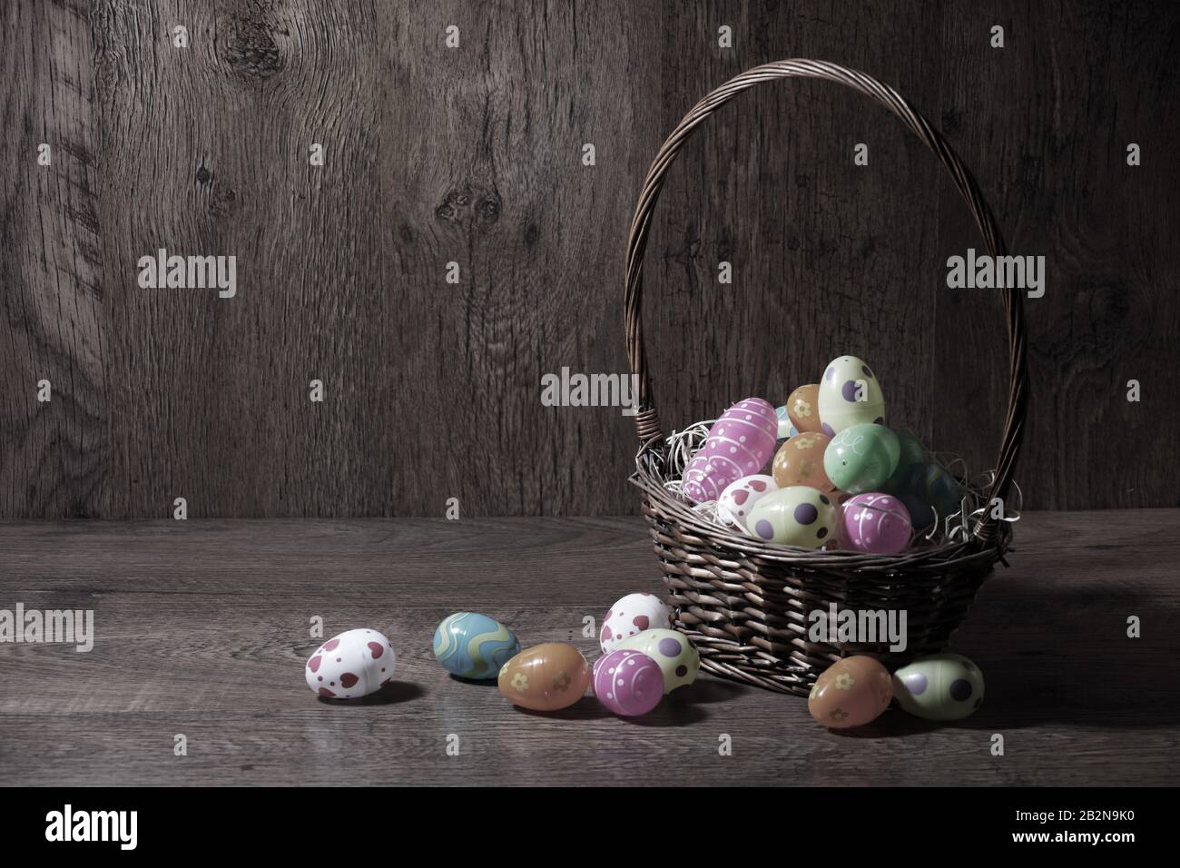 Ein Osterkorb mit Strohhalm und farbigen Eiern Stockfoto