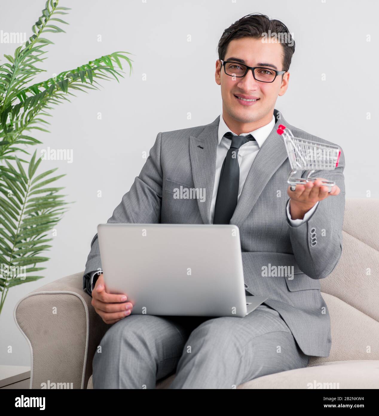 Der Geschäftsmann mit Laptop und Einkaufswagen Stockfoto