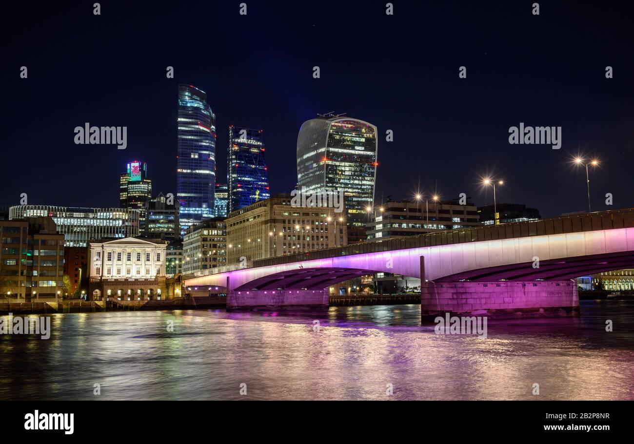 City of London, Großbritannien mit Blick auf die Themse und die London Bridge bei Nacht. Stadtbild mit Wolkenkratzern, Lichtern und dunklem Himmel. London 2020. Stockfoto