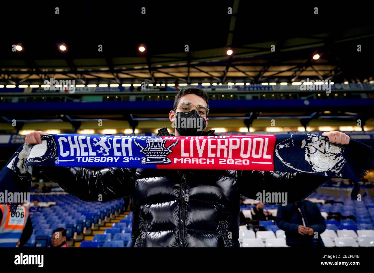 Ein Fan, der eine Gesichtsmaske trägt, hält vor Beginn des fünften Spiels im FA Cup an der Stamford Bridge, London, ein Half Match Schal. Stockfoto
