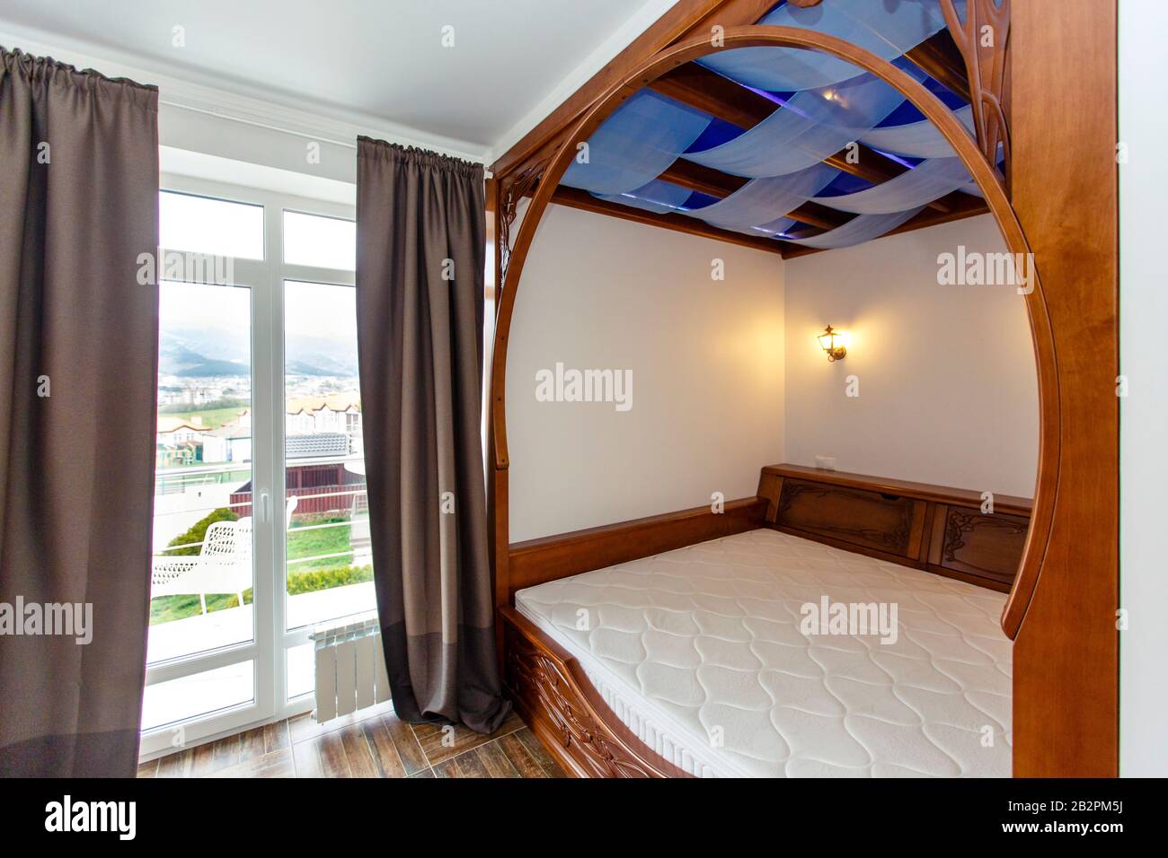 Schlafzimmer im Cottage mit einem großen Holz-Himmelbett. Das Bett ist in  die Wand integriert. Beige Fliesen auf dem Boden Stockfotografie - Alamy