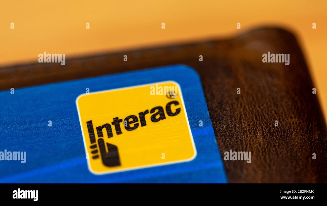 Interac, ein kanadisches Interbank-Netzwerk-Logo auf einer blauen Karte, auf der braunen Brieftasche. Stockfoto