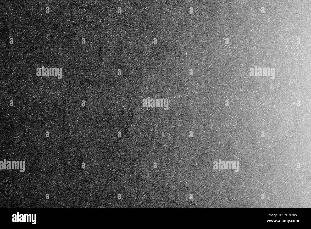 Fehlender und weißer Hintergrund aus echtem schwarzen Papier mit weißen Punkten, von rechts durch ein weiches Licht beleuchtet. Stockfoto