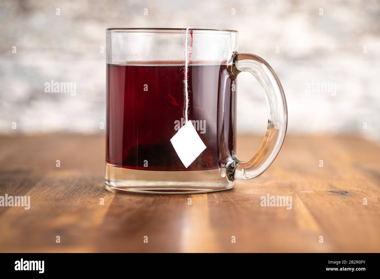 Obsttee in Glasküken auf Holztisch. Stockfoto