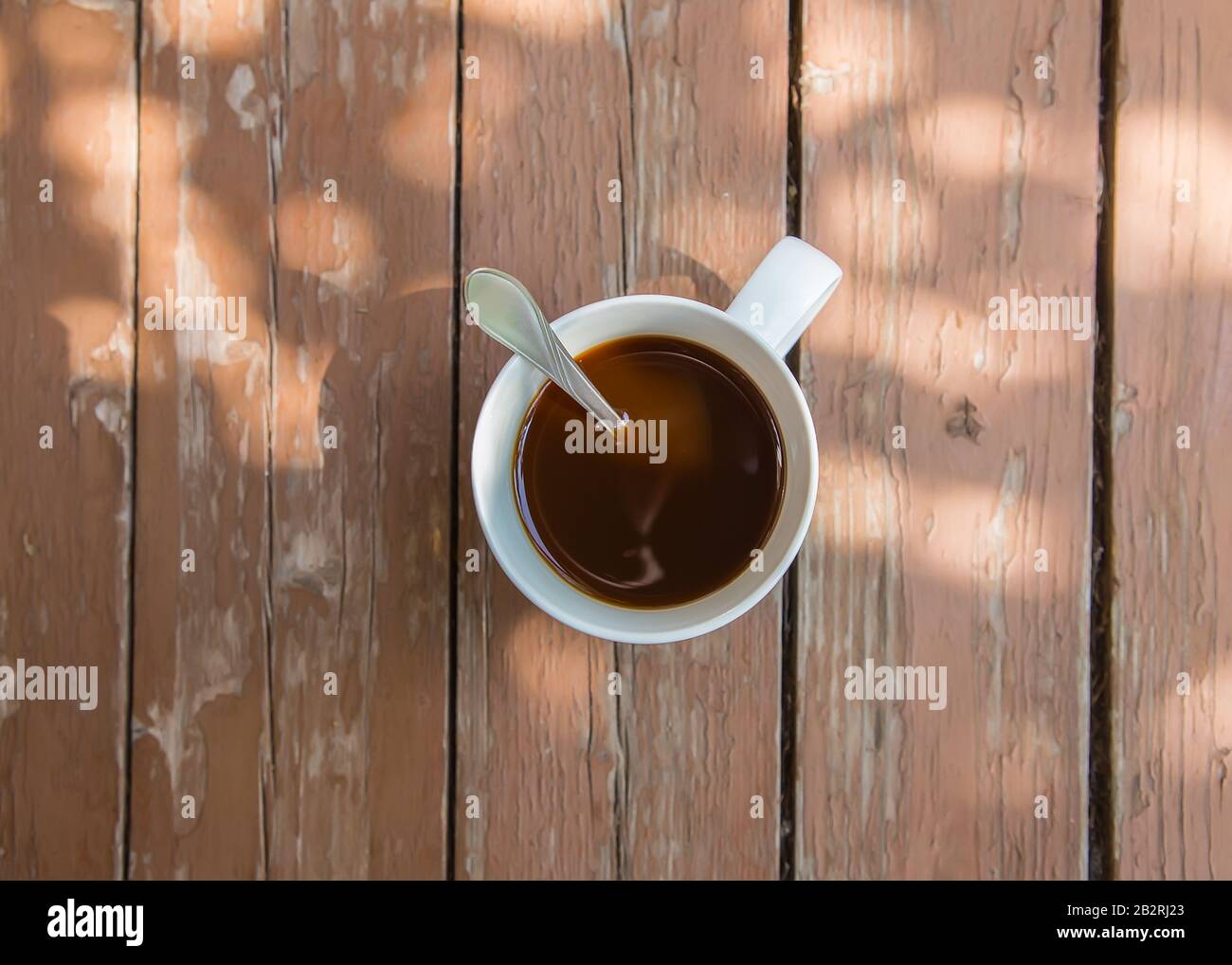 Tasse Kaffee am Tisch in den Strahlen der Sonne am Morgen Stockfoto
