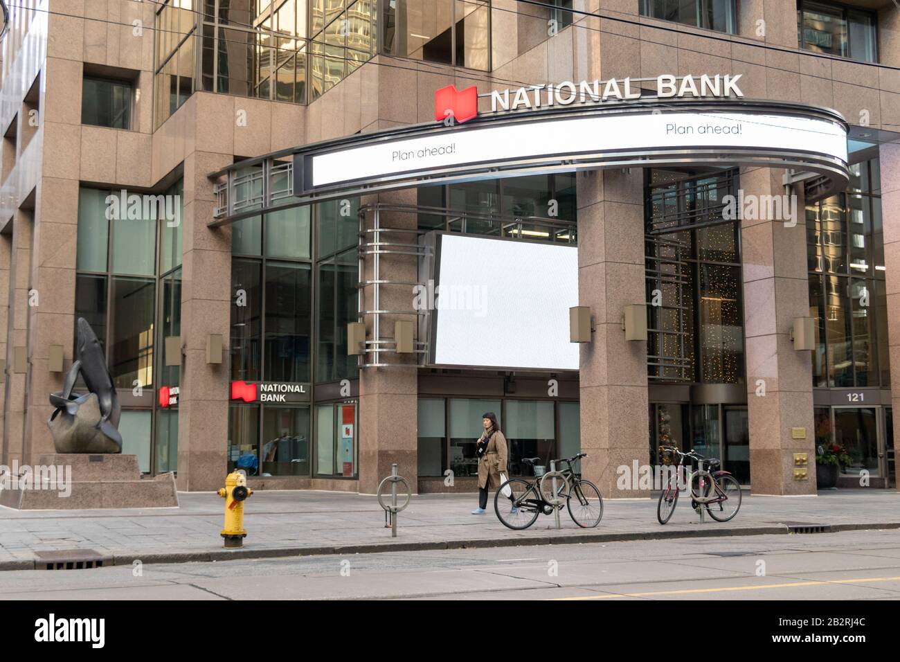 Vor einer Filiale der National Bank in der Innenstadt von Toronto, während eine Frau an einem sonnigen Nachmittag vorbei geht. Stockfoto