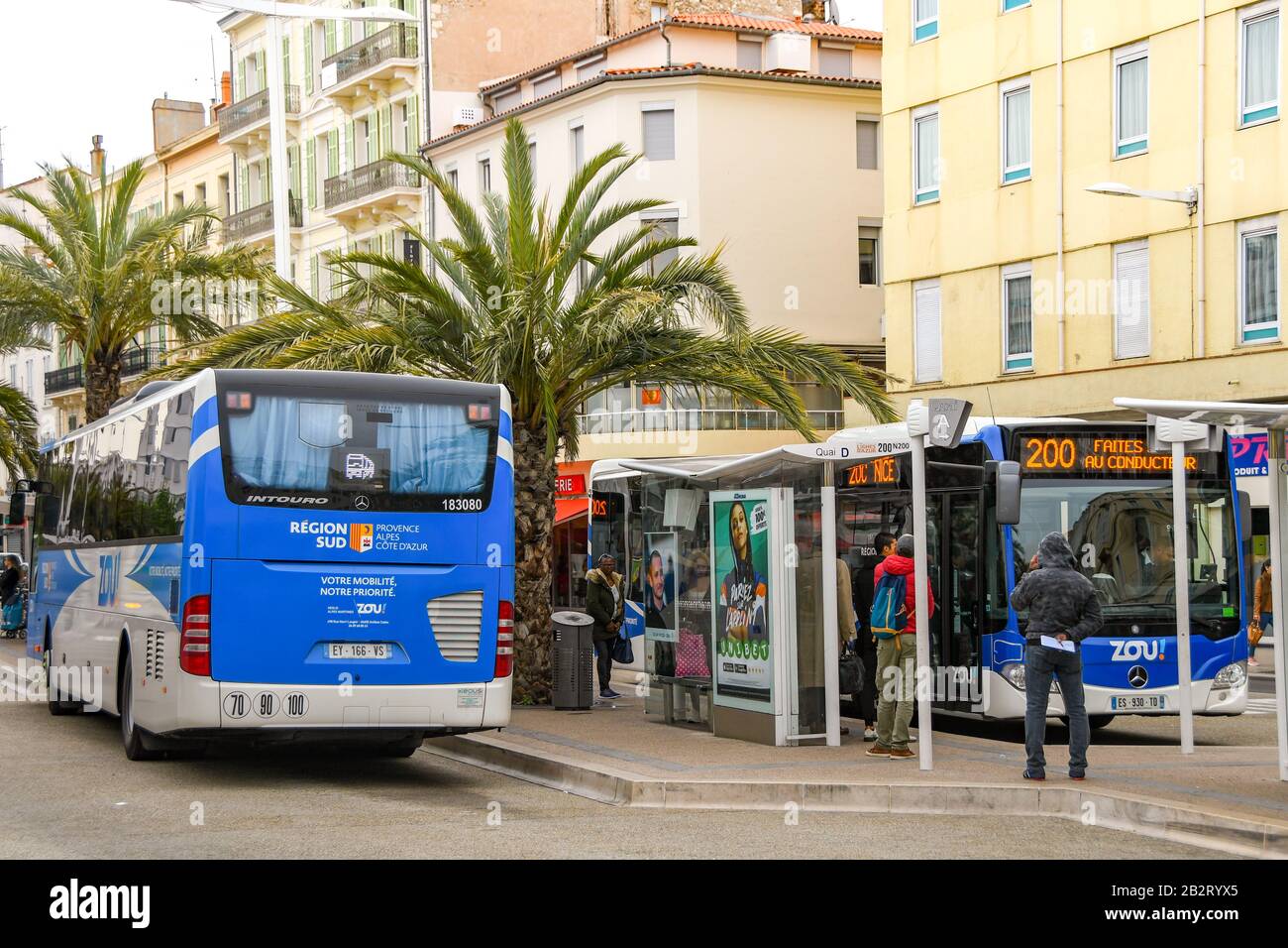 Cannes, FRANKREICH - APRIL 2019: Busse, die an Bushaltestellen vor dem Bahnhof im Zentrum von Cannes warten. Stockfoto Cannes, FRANKREICH - APRIL 2019: Busse, die an Bushaltestellen vor dem Bahnhof im Zentrum von Cannes warten. Stockfoto