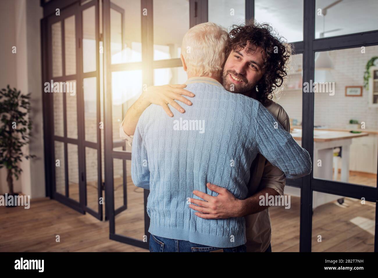 Vater und Sohn umarmen sich zu Hause. Konzept der familiären Beziehung Stockfoto