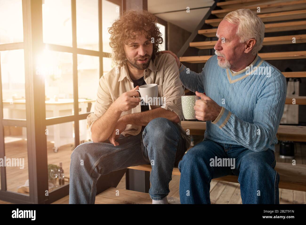 Vater und Sohn trinken gemeinsam einen Kaffee. Konzept der familiären Beziehung Stockfoto