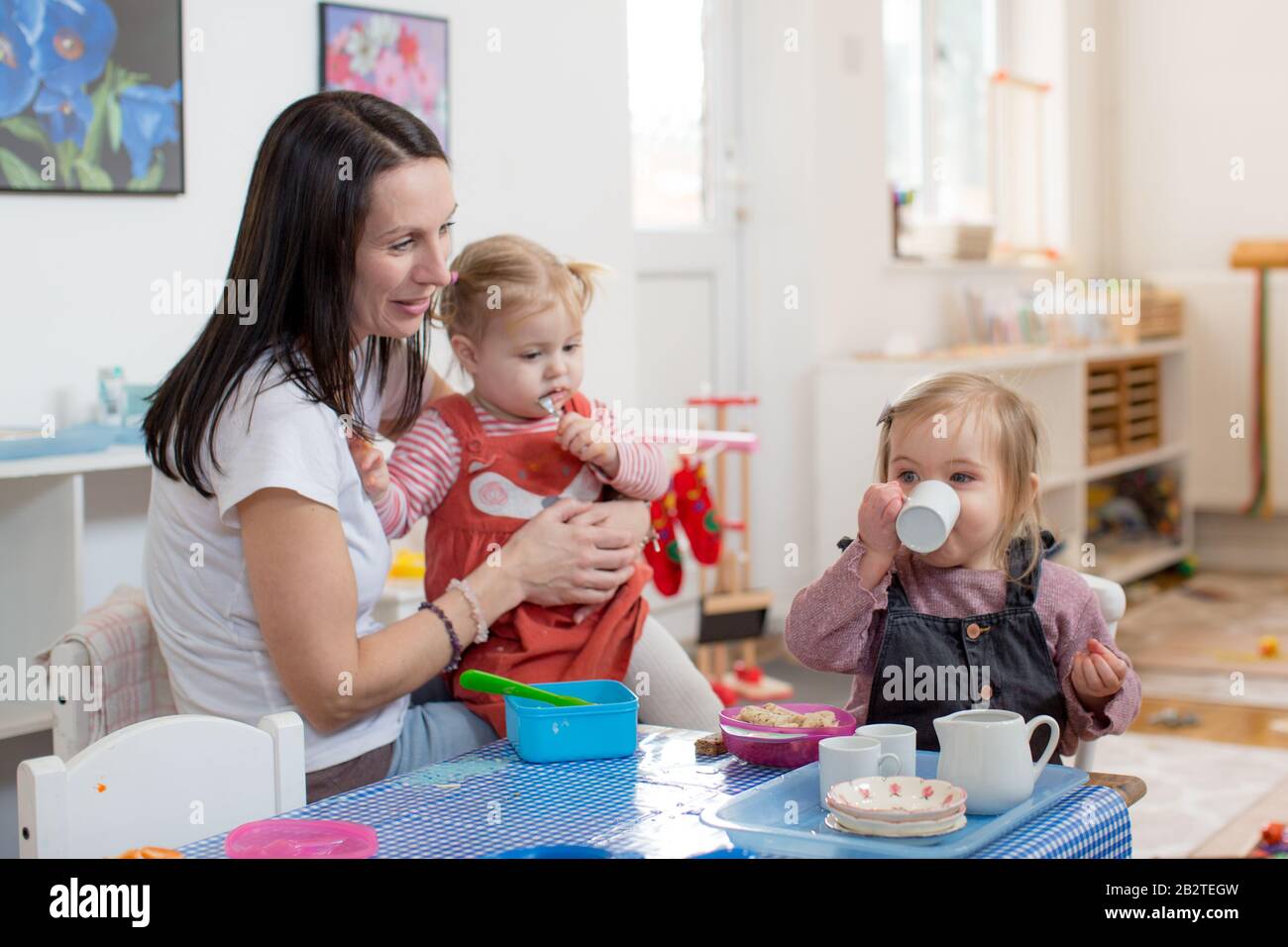 Lehrer und Kleinkinder an einem Tisch spielen vorgeben, Großbritannien Stockfoto