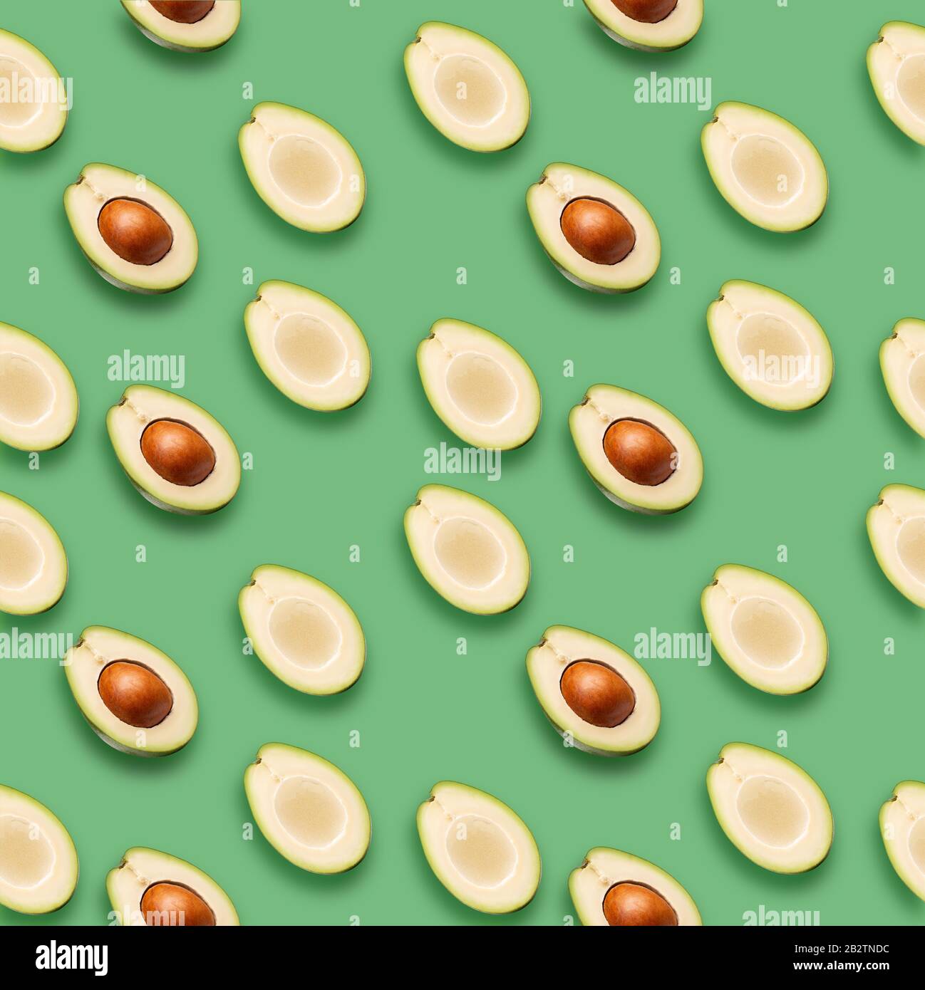 Muster mit Avocado-Schichten auf grünem Hintergrund. Stockfoto