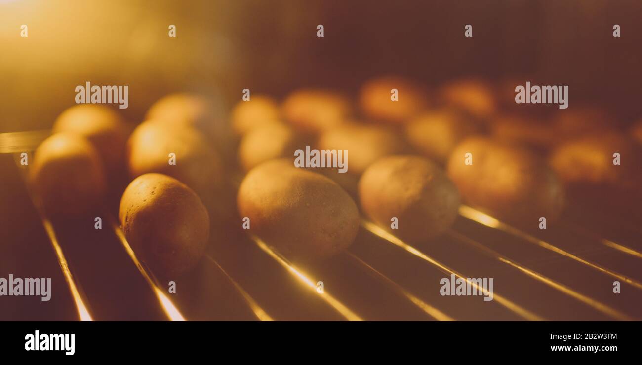 Ganze Kartoffeln in der Schale im heißen Ofen gebacken. Stockfoto