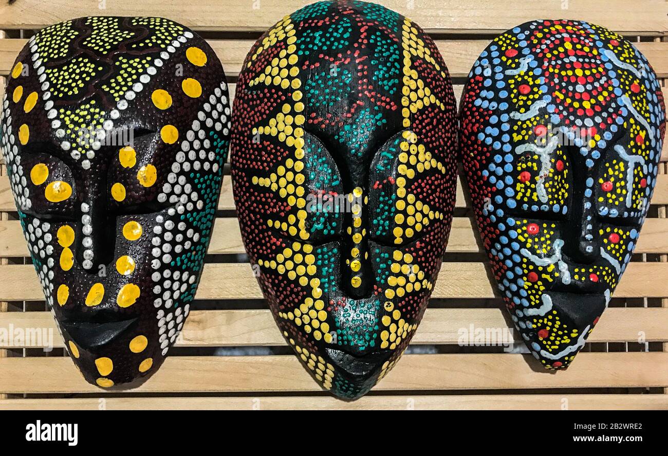 Afrikanische Kultur Tribal Holzrückenmasken in bunten Punkten gemalt Stockfoto