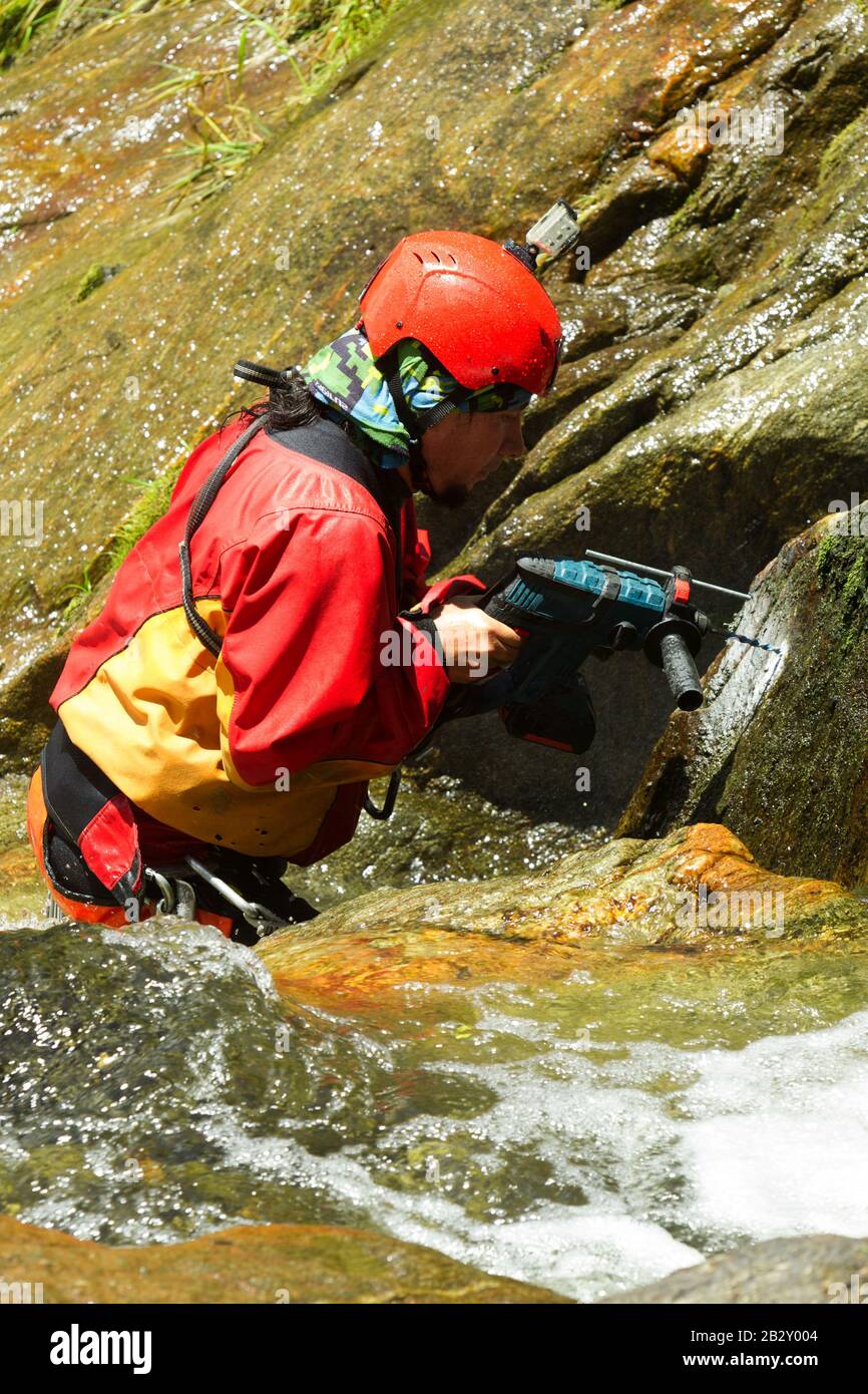 Lehrer Bohren Löcher Für EINEN neuen Canyoning-Kurs In Chama Waterfall Ecuador Stockfoto