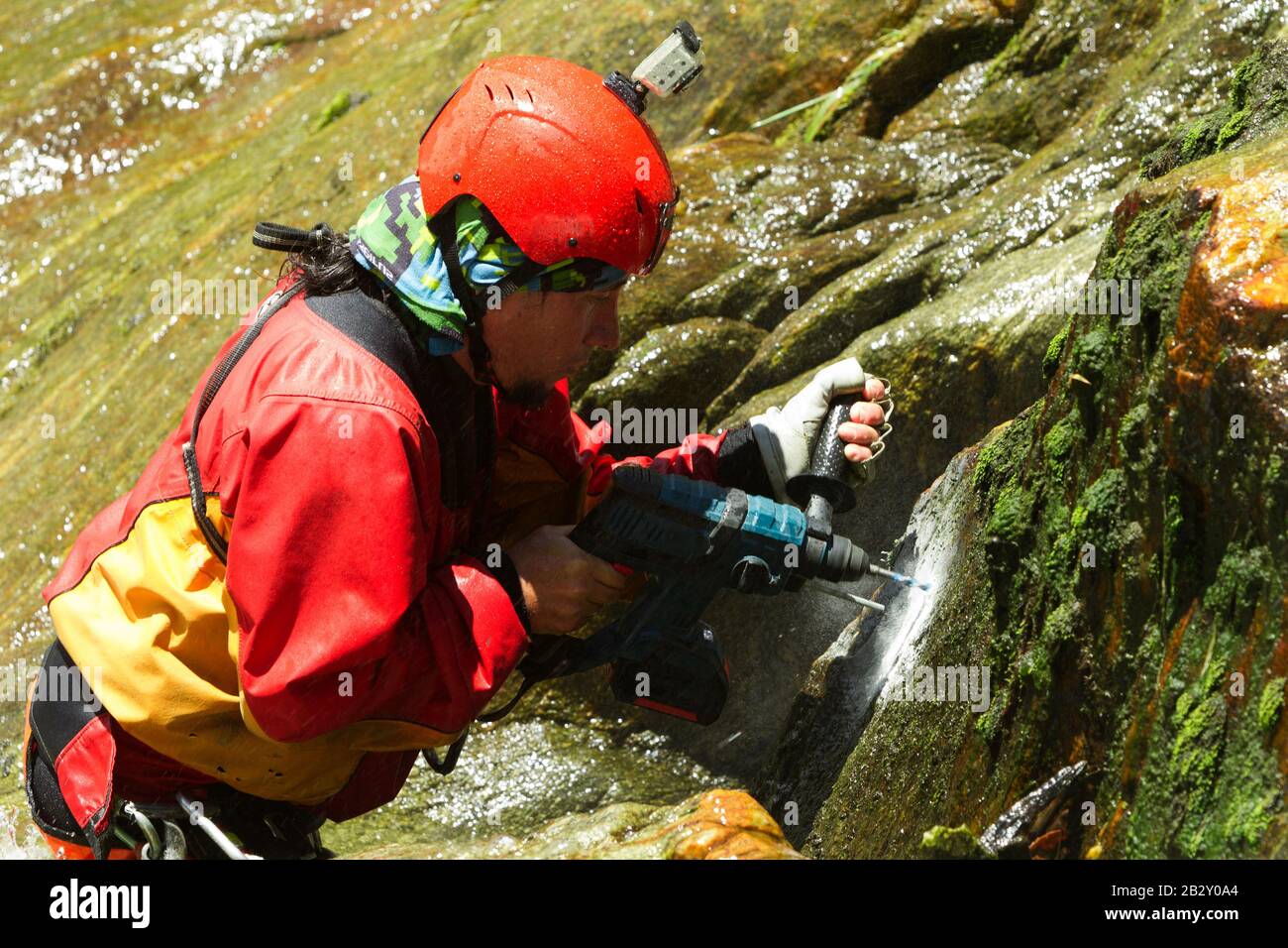 Der Kursleiter Bohren Löcher Für EINEN neuen Canyoning-Pfad Im Chama-Wasserfall Ecuadors Stockfoto