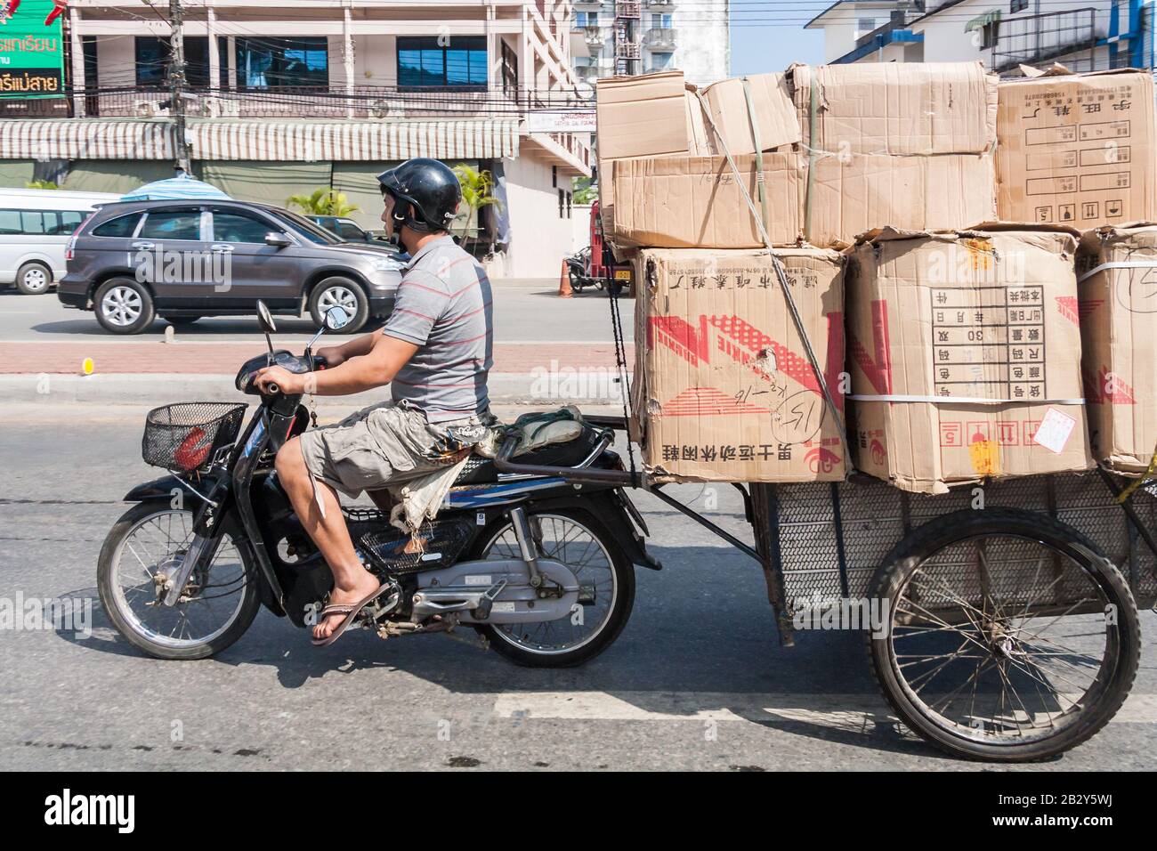 Mae Sai, Thailand - 29. November 2011: Burmesische Männer auf dem Motorrad, die Waren zurück nach Myanmar transportieren. Viele verschiedene Waren werden über die Borde transportiert Stockfoto