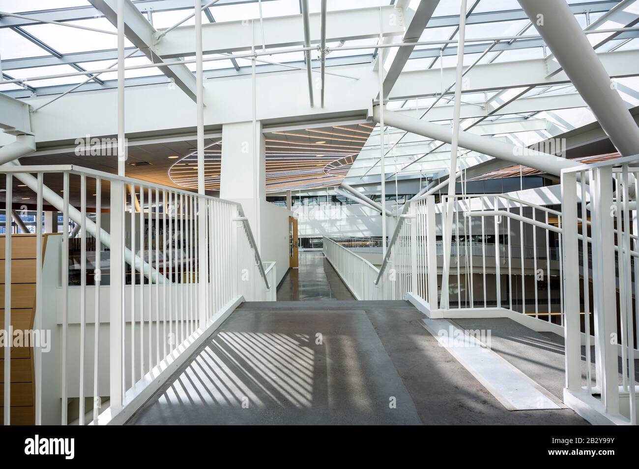 Das Innere eines Lichtgebäudes mit einer Glasdecke und Teil einer Hängebrücke zwischen den Etagen unter Verwendung moderner Designelemente und interessanter Engi Stockfoto