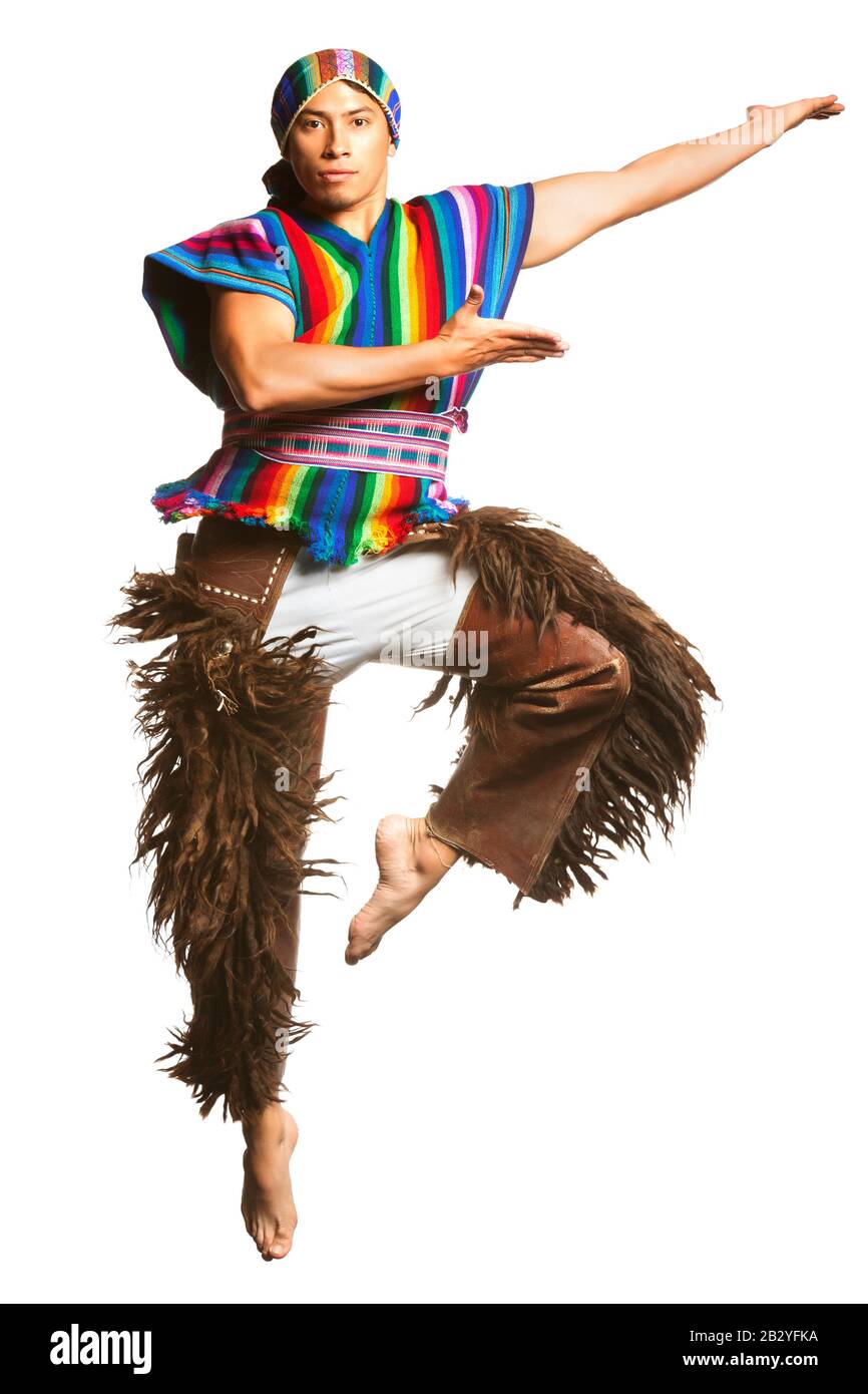 Ecuadorianische Tänzerin, die die Kultur der Anden in traditioneller Kleidung präsentiert, einen dynamischen Sprung mit Lama- oder Alpakahosen, aufgenommen in einem Studio-Setting ag Stockfoto
