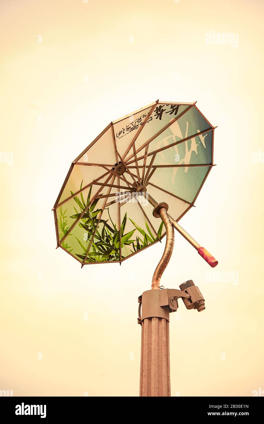 Dekorativer Lampenpfosten in Form eines chinesischen Regenschirms auf gelbem Himmelshintergrund Stockfoto