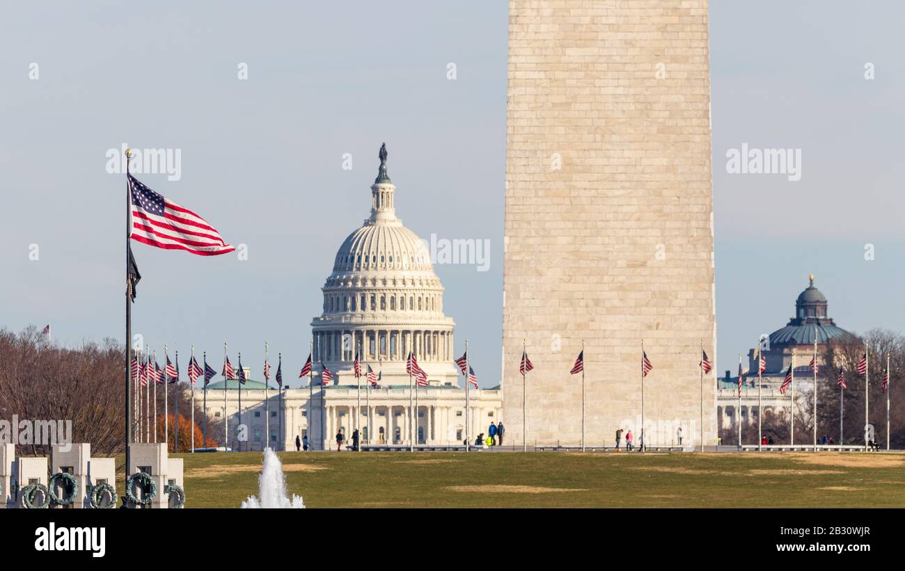 Amerikanische Flagge schwenkt beim Blick auf die National Mall am Fuß des Washington Monument und des US Capitol Building. Stockfoto
