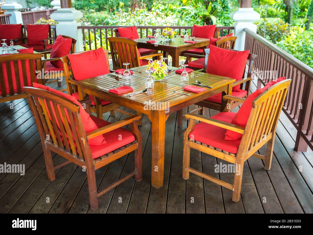 Farbenfrohes, wunderschönes Orchideen-Bouquet-Dekor in Glasvase, eingerichtet auf einem Holz-Esstisch in Indien, Empfang für Hochzeitsfeiern. Stockfoto
