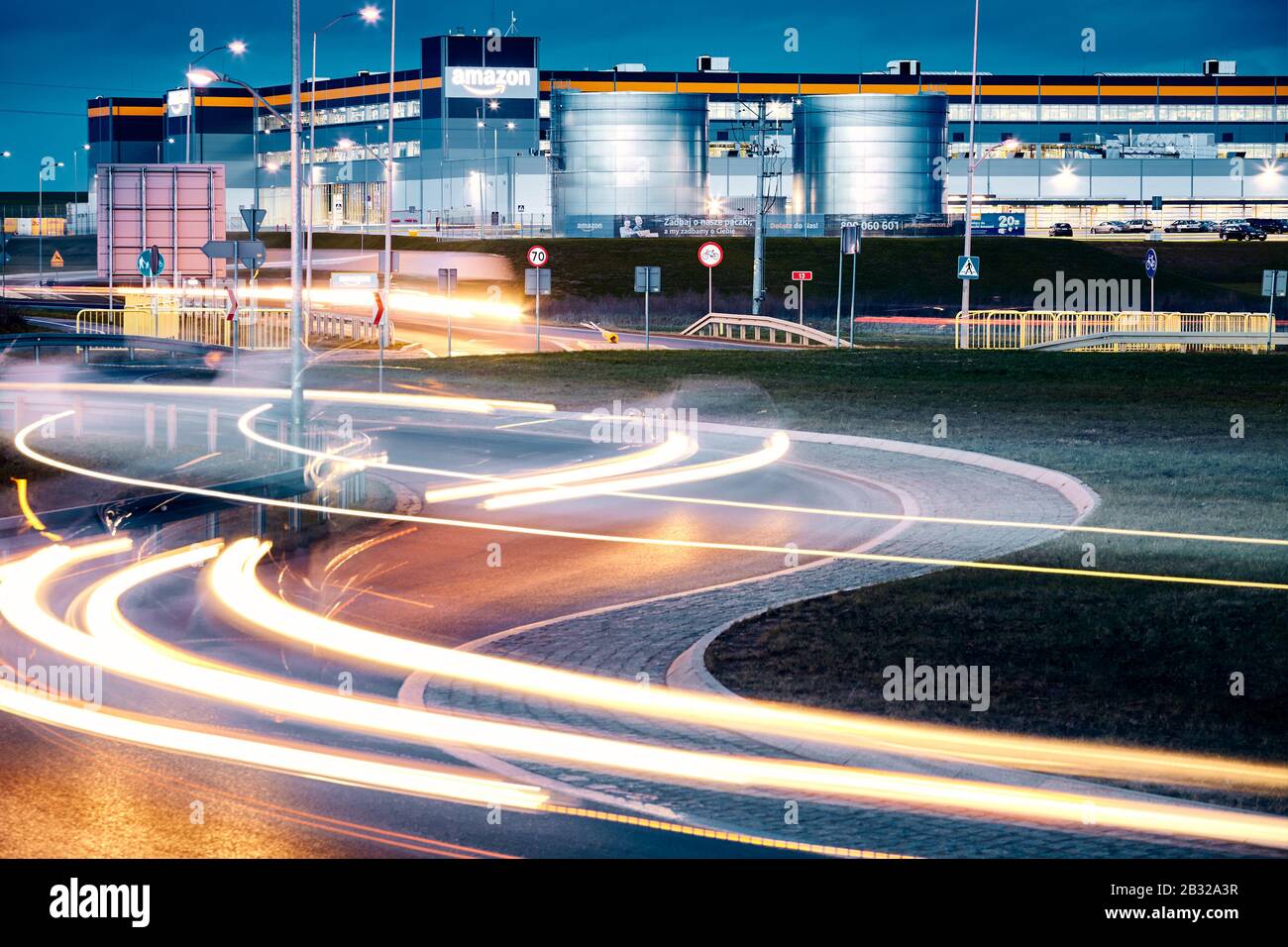 Kolbaskowo, Polen - 28. Februar 2020: E-Commerce-Zentrum Amazon Robotics in Kolbaskowo mit Ampelwegen in der Abenddämmerung im Vordergrund. Stockfoto