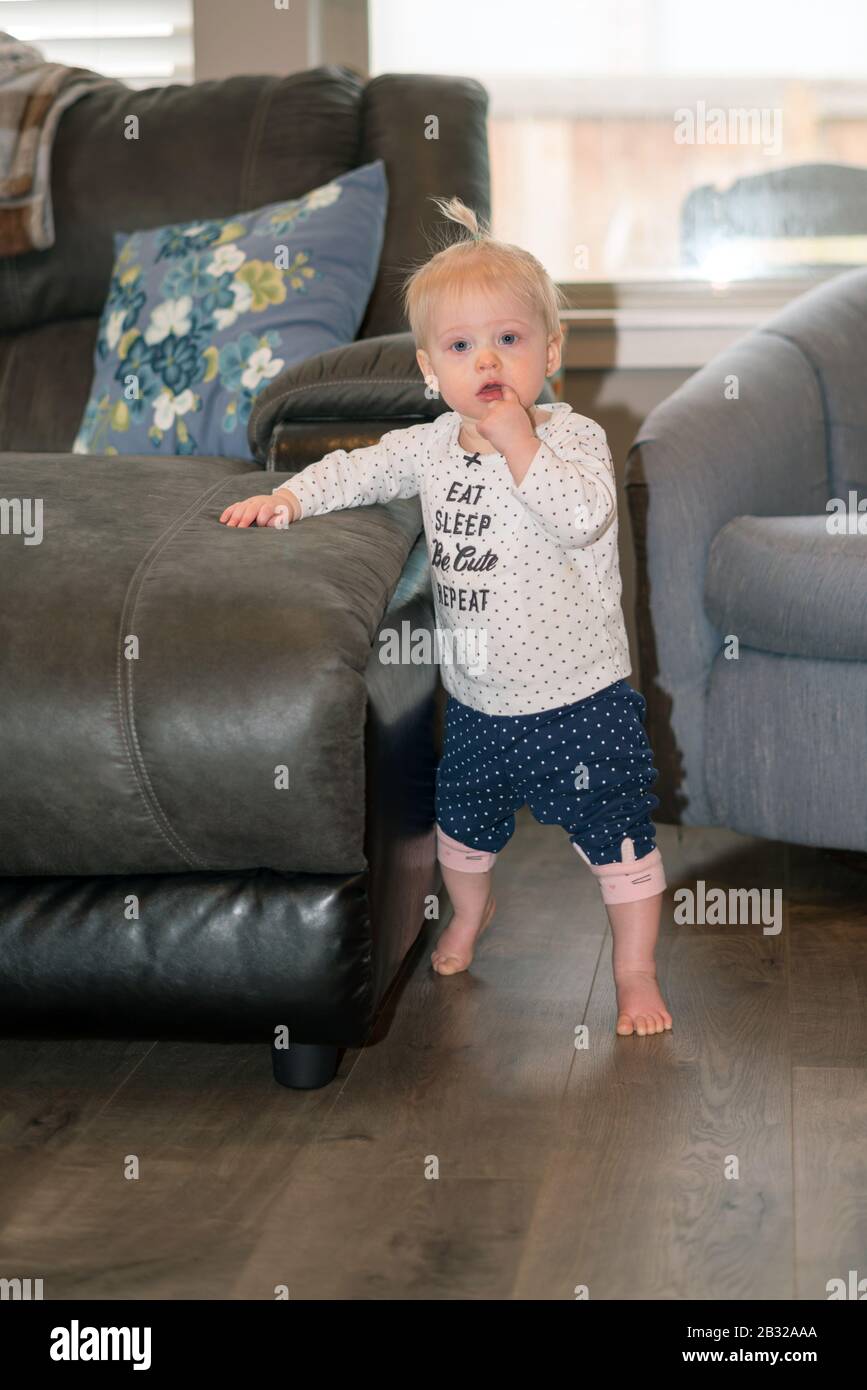 Niedliches Baby Girl Lernen Sie, Auf Den Füßen Zu Stehen Stockfoto