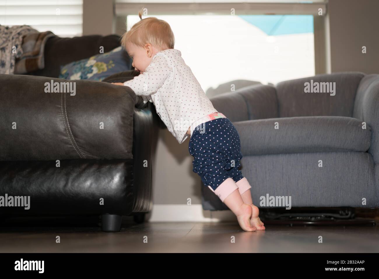 Niedliches Baby Girl Lernen Sie, Auf Den Füßen Zu Stehen Stockfoto