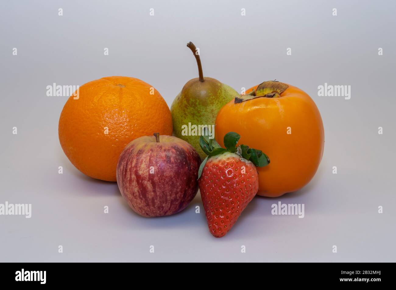 Erdbeere, Apfel, Persimmon, Orange, Pear Rock. Abwechslungsreiche Früchte sind essentiell für eine gesunde und ausgewogene Ernährung. Stockfoto