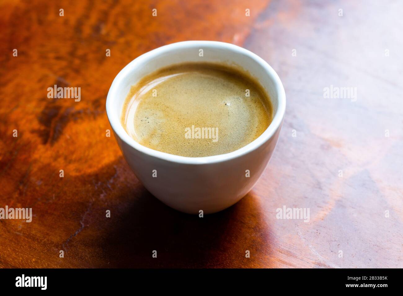 Tasse Kaffee in einem hübschen Hipper-Café. Weich fokussiertes Bild. Tasse Espresso auf dem alten Holztisch der Cafeteria. Stockfoto