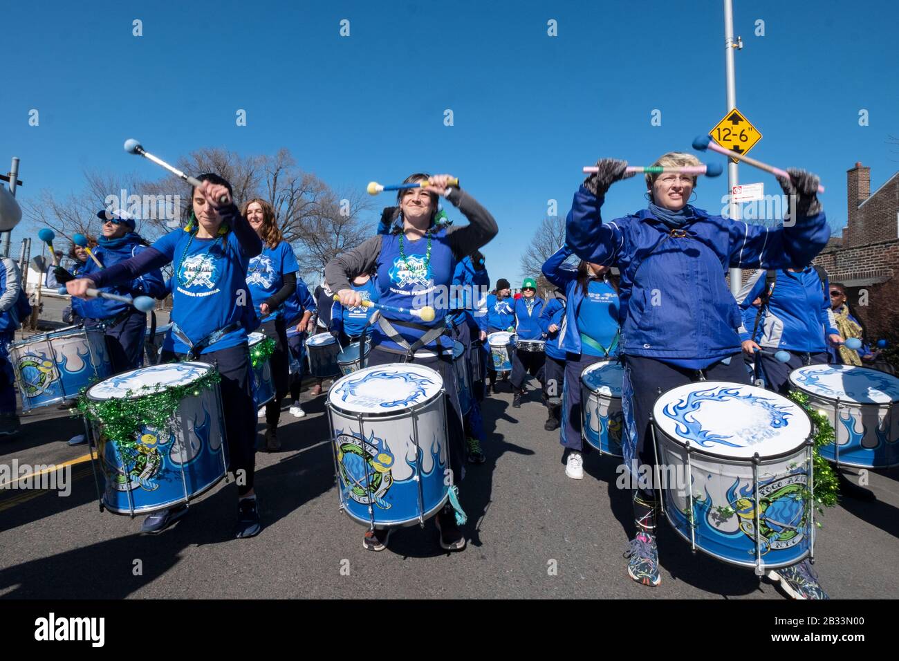Mitglieder der Fogo Azul All-female Drumline Marching Band wärmen sich vor dem Aufmarsch in der St. Patrick's Day Parade für Alle in Sunnyside, Queens, NYC auf Stockfoto
