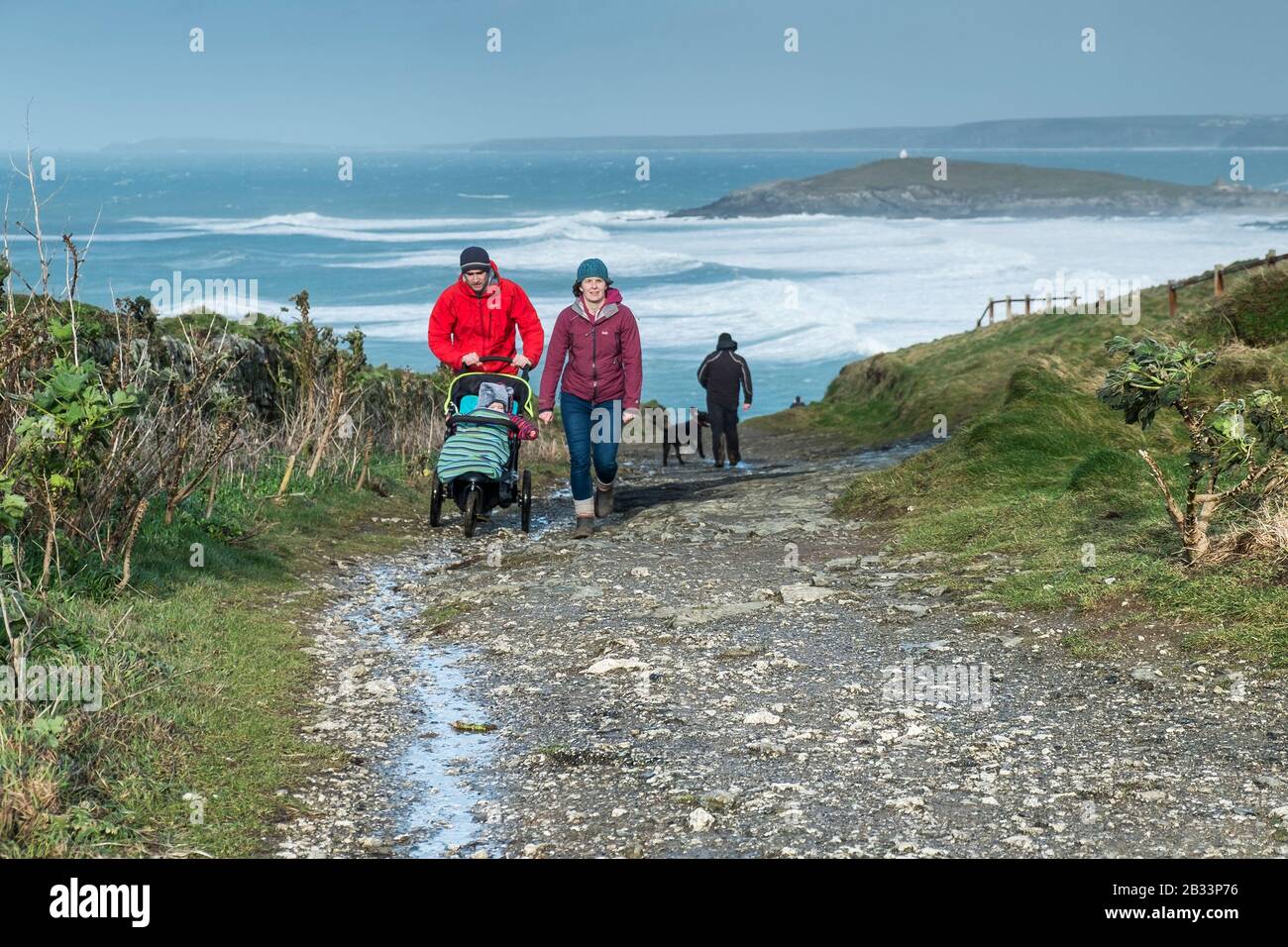 Eine junge Familie, die auf dem South West Coast Path in South Fistral in Newquay in Cornwall spazieren geht. Stockfoto