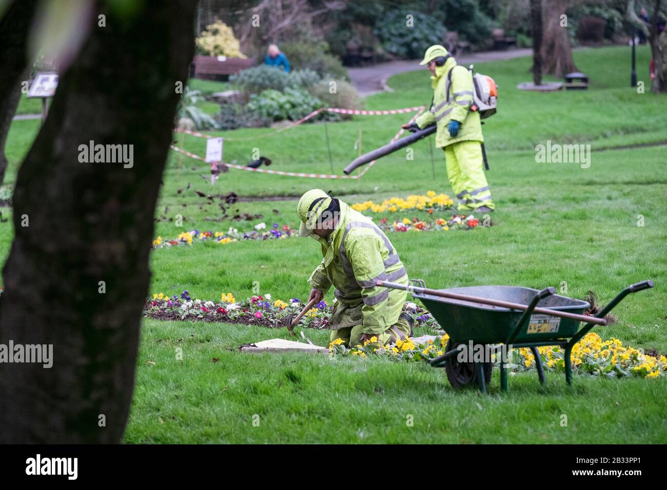 Gartenpflegearbeiter, die Hi-Vis-Kleidung tragen, arbeiten in den Trenance Gardens in Newquay in Cornwall. Stockfoto