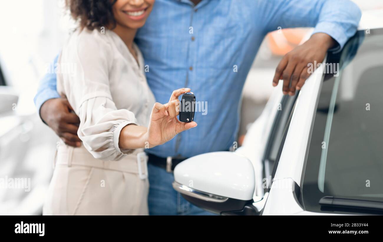 Unerkennbares Paar, Das Den Neuen Autoschlüssel In Der Händlerniederlassung, Panorama, Zeigt Stockfoto