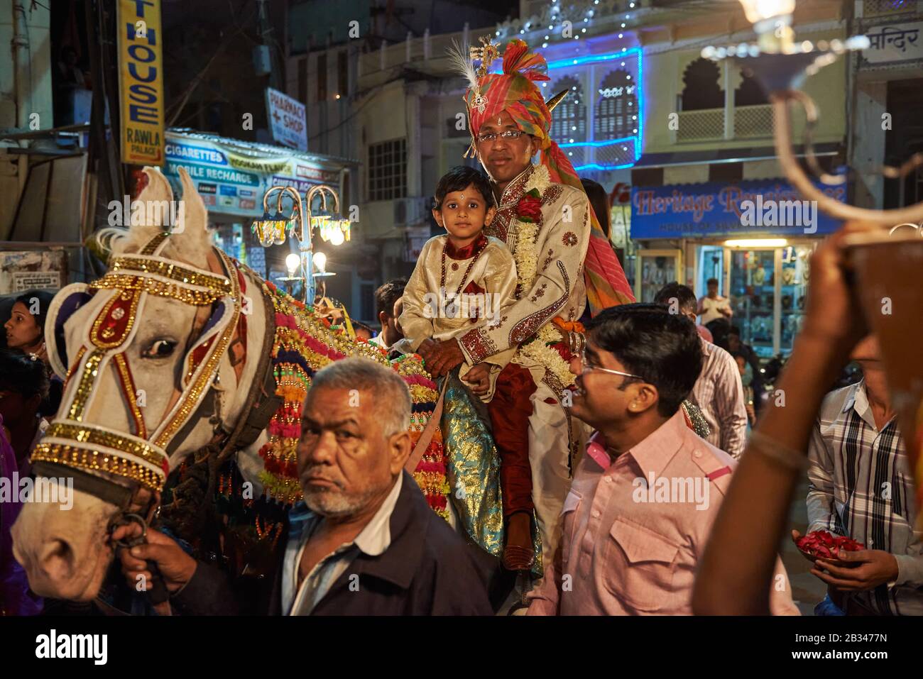 Nachtaufnahme eines Brautzimmers mit Junge und Mädchen auf einem Pferdezug durch die Straßen von Udaipur, Rajasthan, Indien Stockfoto