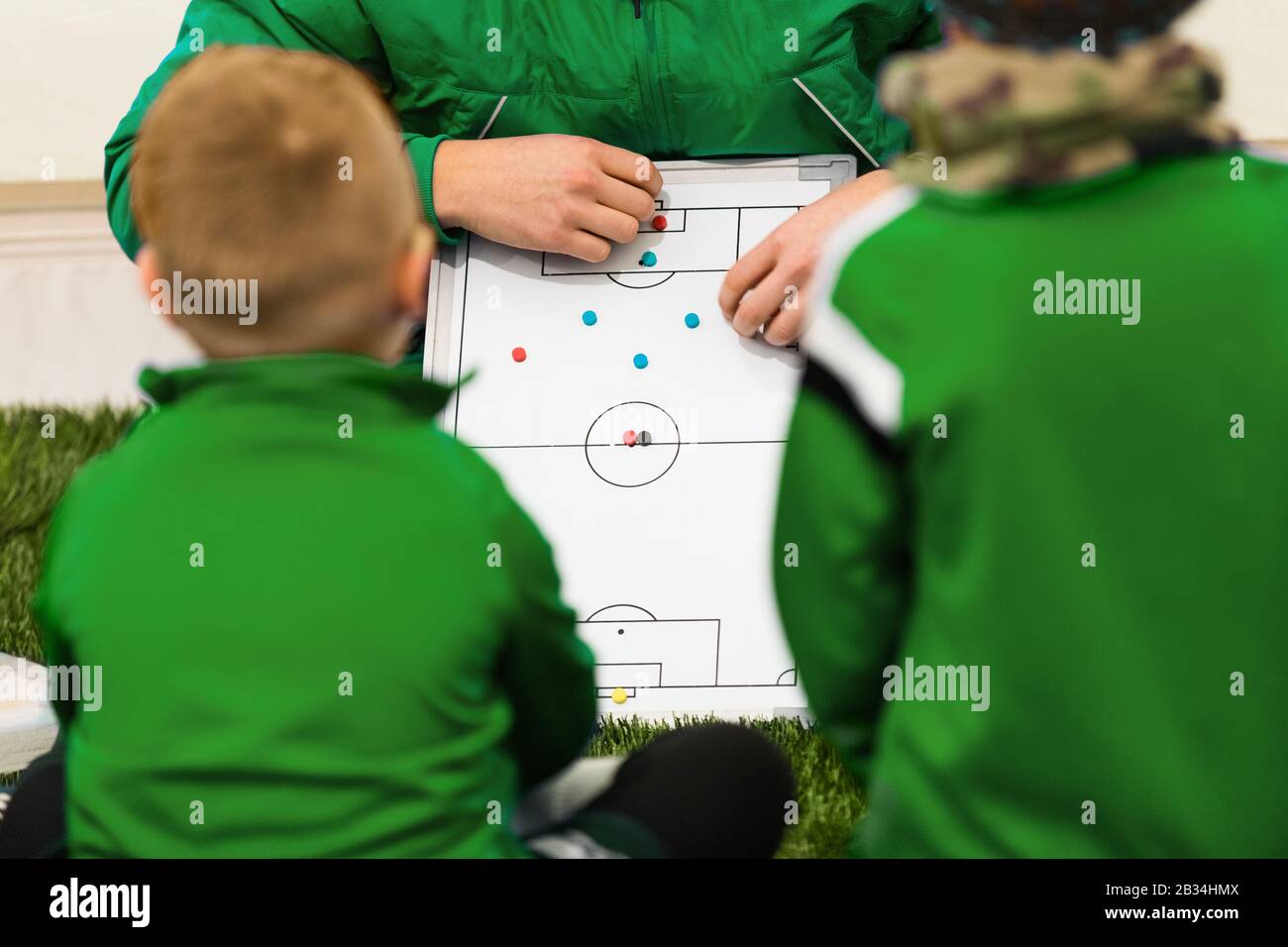Fußball-Trainer erklärt dem Fußballteam der Kinder Taktiken. Trainer ...