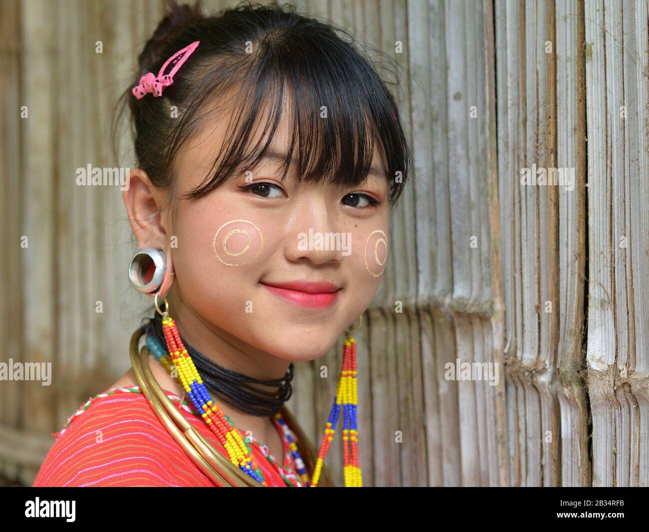 Hübsches Kayaw (Kayor) Teenager-Mädchen mit traditionellen burmesischen Thanaka Gesicht Kosmetik auf ihren Wangen und markante Tribal-Ohrenstöpsel für die Kamera. Stockfoto