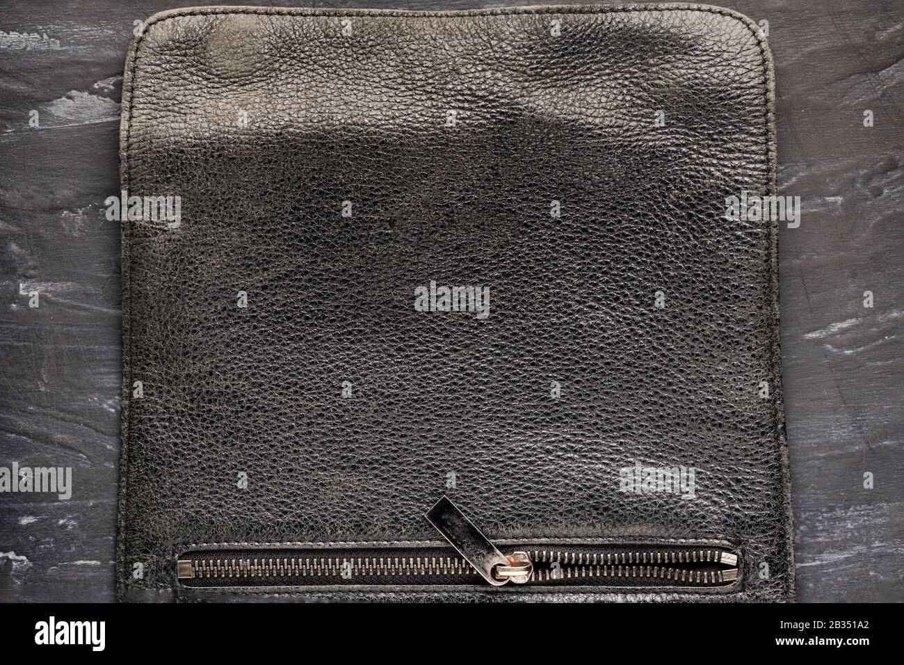 Hintergrundtextur schwarzes Leder. Tasche mit einem Schloss und einem formschönen, bügelnahen, eleganten Schabby-Reißverschluss-Schloss Stockfoto