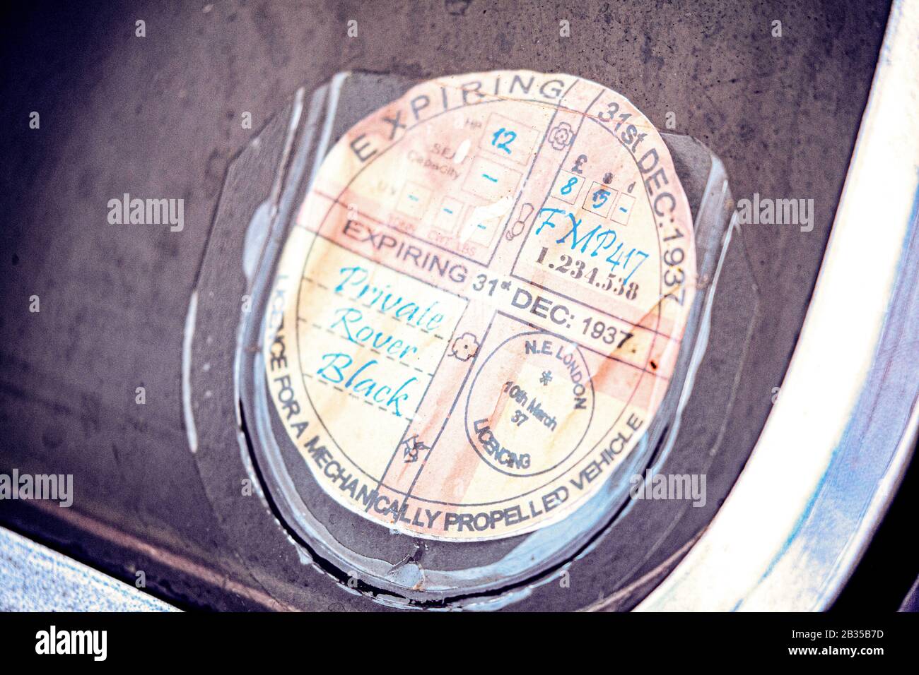Nahaufnahme einer alten Kfz-Steuerscheibe vom Dezember 1932 auf dem Bildschirm eines alten Autos. Stockfoto