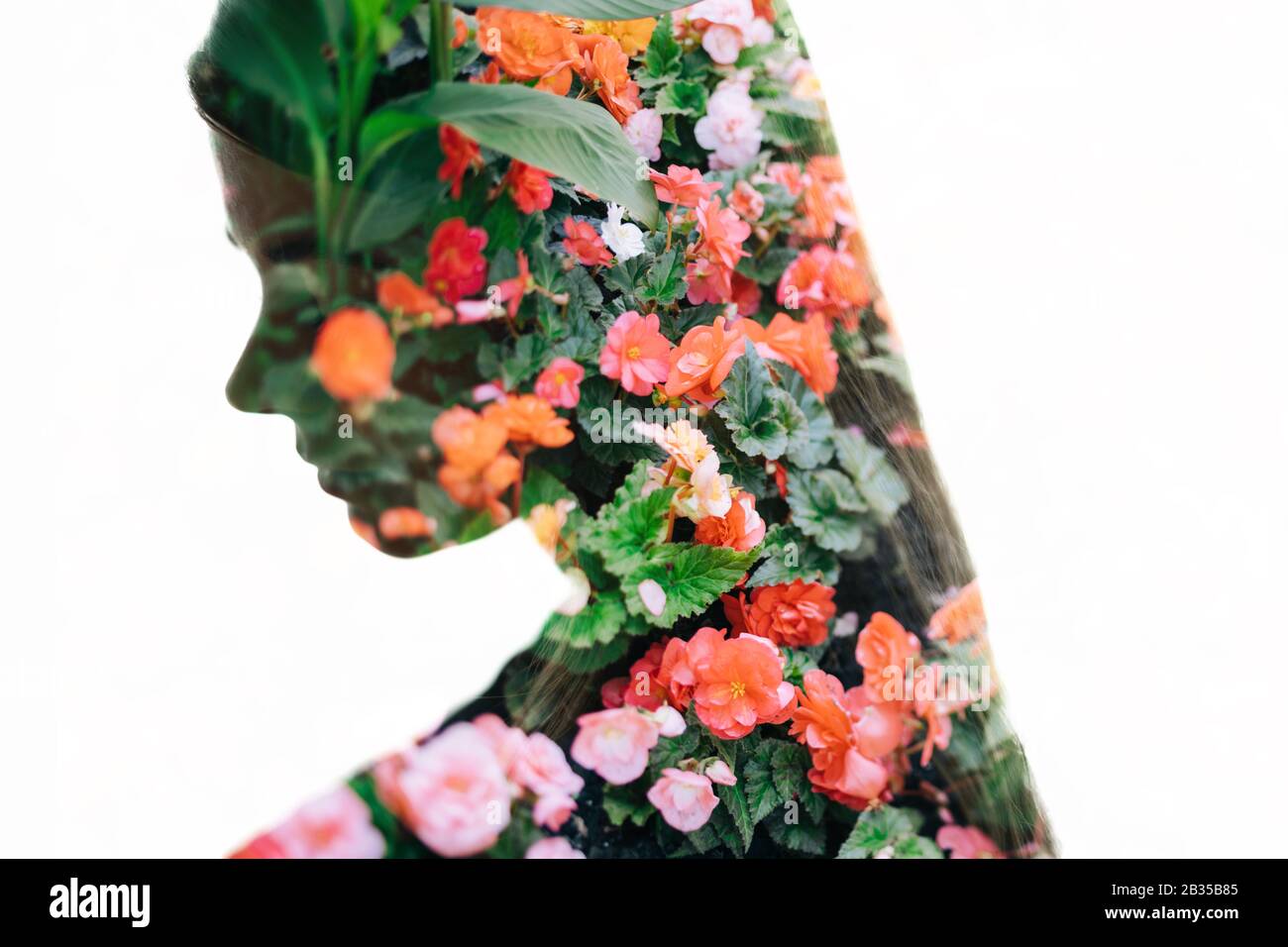 Porträt einer hübschen Frau mit langen Haaren und Sommerblumen Hintergrund (Doppelbelichtung, Verwacklungsunschärfe) Stockfoto