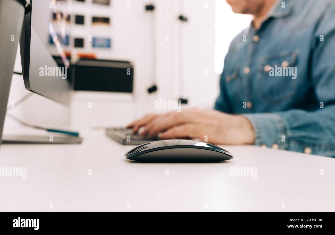 Der Mann, der in einem modernen weißen Büro arbeitet, konzentriert sich selektiv auf das nächste Stockfoto