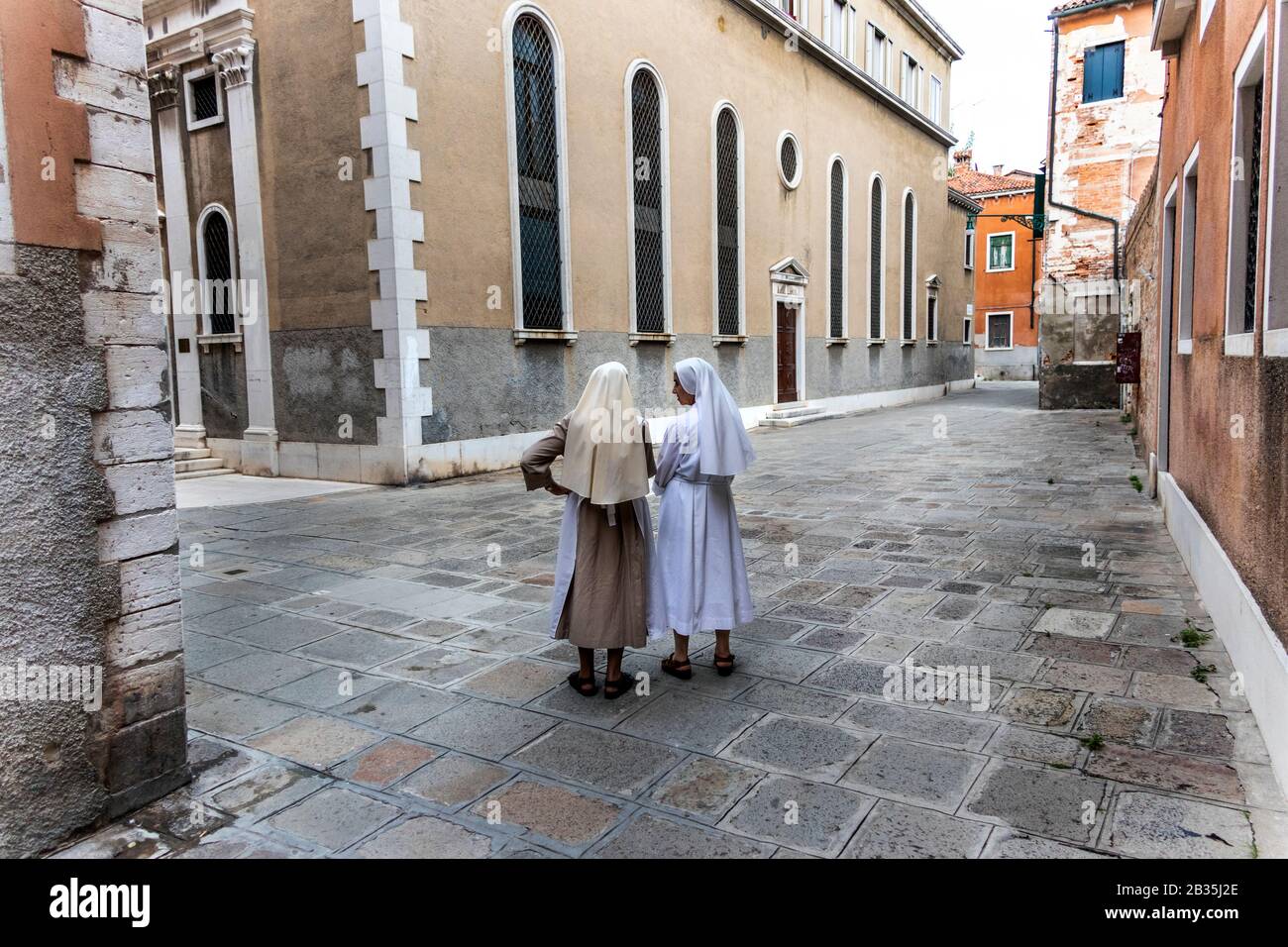 Zwei ältere Nonnen, die in einer ruhigen Straße, Venedig, Italien, sprechen Stockfoto